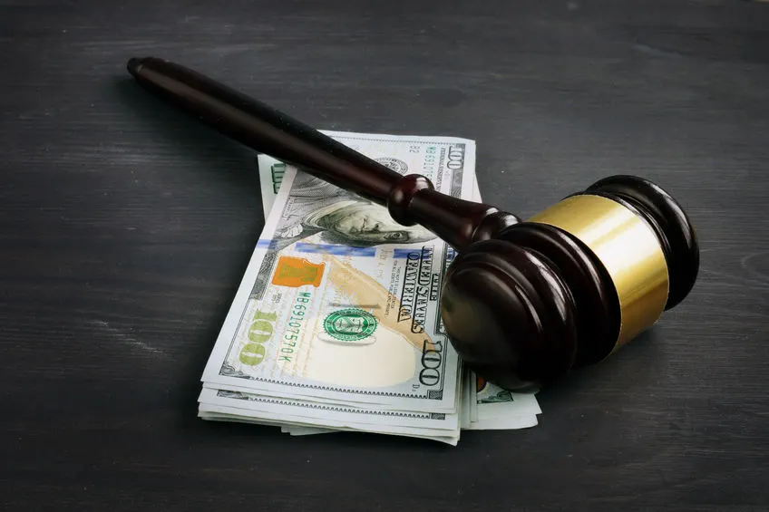 A judge 's gavel and money on top of a table.