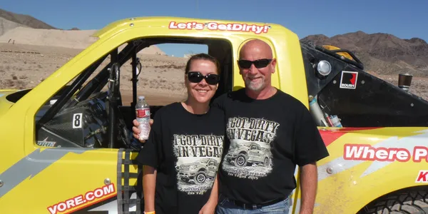 A man and woman standing in front of a truck.